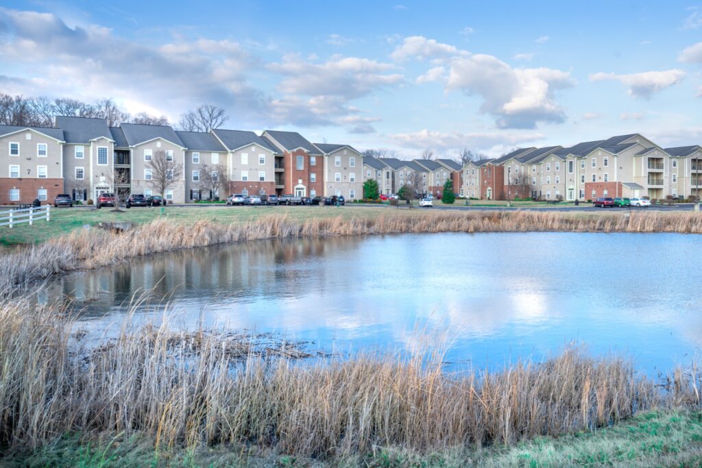 Exterior view of apartment buildings with small pond in the foreground