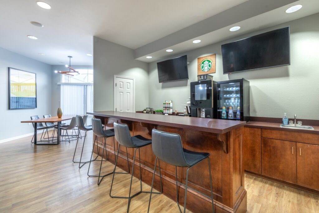 Clubhouse lounge drink station with coffee machine and mini fridge