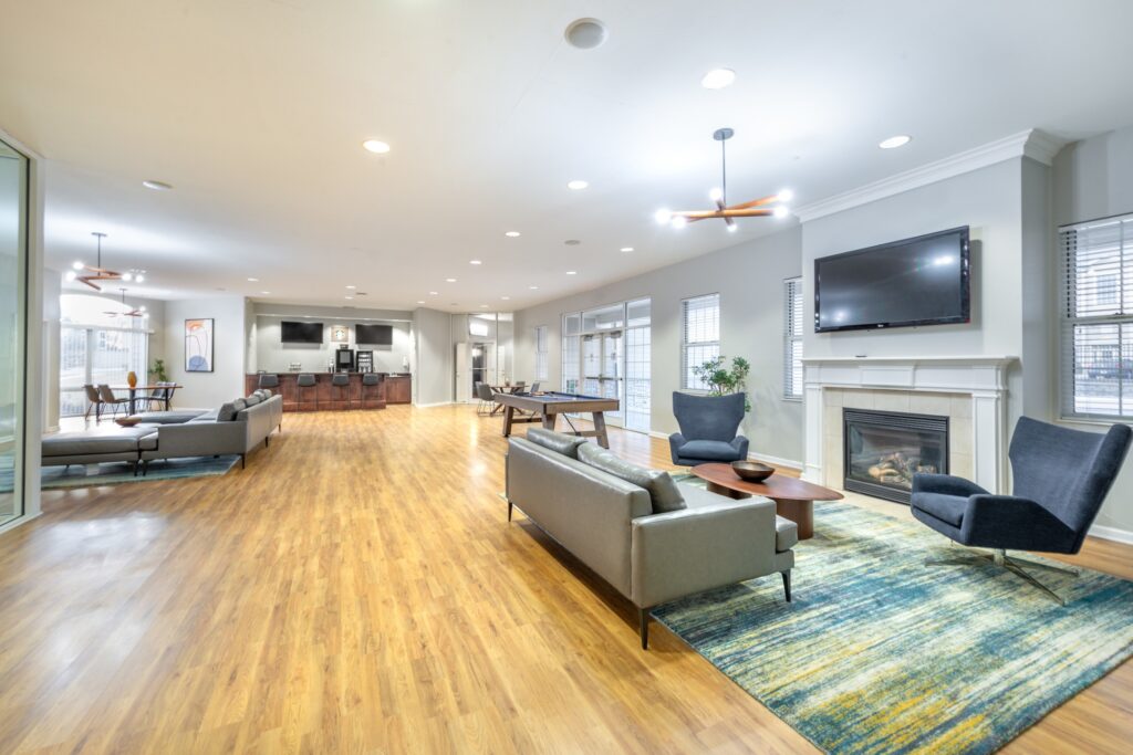 Clubhouse lounge with Billiards table and sofas around a fireplace, and a drink station