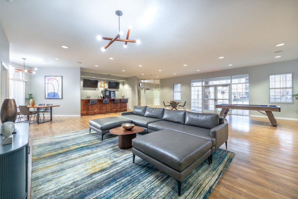 Clubhouse lounge with Billiards table and sofas around a TV, and a drink station