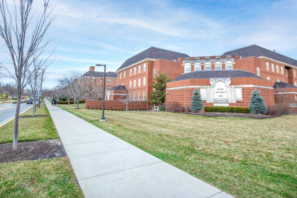 External view of Miami university, tree lined sidewalk outside large brick buildings